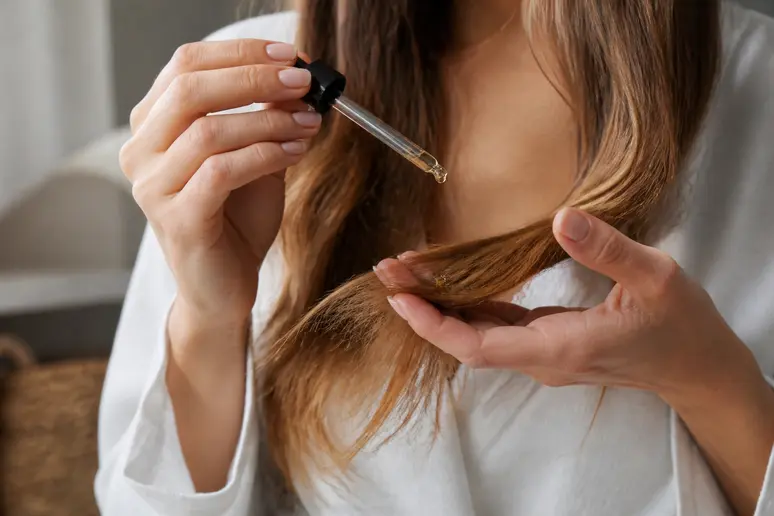 Application d'huile végétale nourrissante sur les longueurs avant le shampooing capillaire